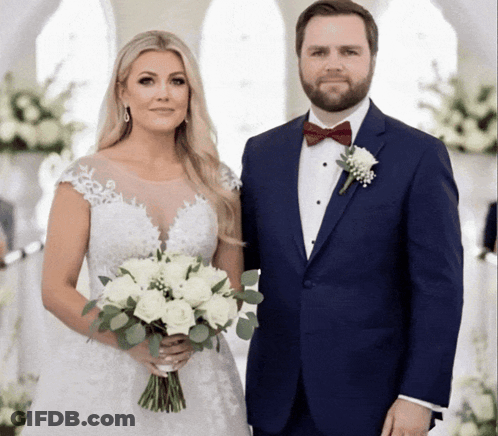 A Bride And Groom Pose For A Picture While The Bride Is Holding A Bouquet Of White Flowers GIF