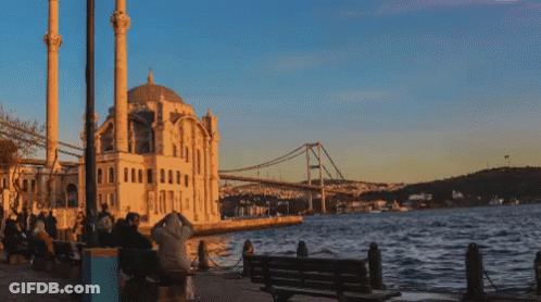 A Bridge Over A Body Of Water In Front Of A Mosque GIF