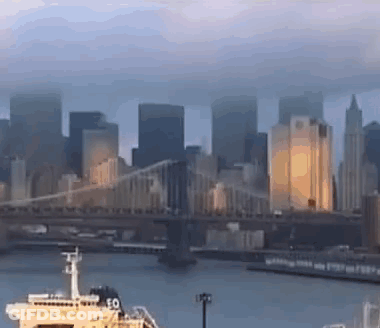 A Bridge Over A Body Of Water With A Boat In The Foreground GIF