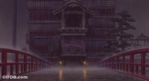 A Bridge Over A Body Of Water With A Building In The Background In The Rain GIF