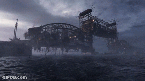 A Bridge Over A Body Of Water With A Dark Sky In The Background GIF