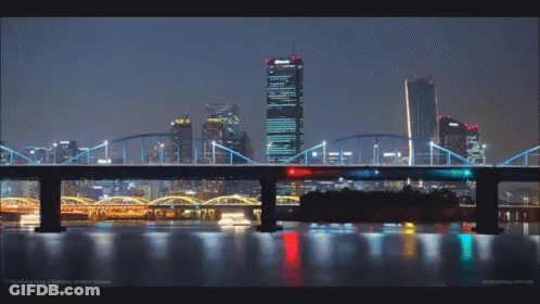A Bridge Over A Body Of Water With Buildings In The Background GIF
