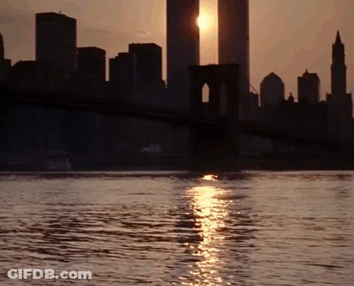 A Bridge Over A Body Of Water With The Sun Shining On It GIF