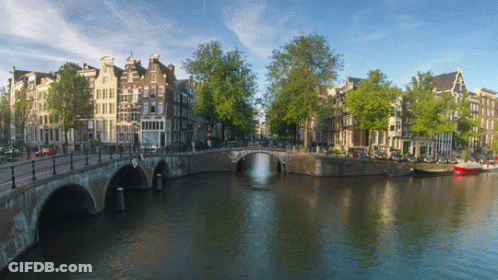 A Bridge Over A River Surrounded By Buildings GIF
