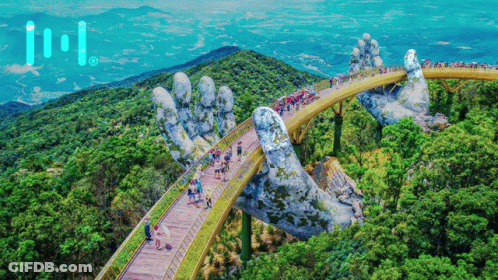 A Bridge That Looks Like A Giant Hand Is Surrounded By Trees And People GIF