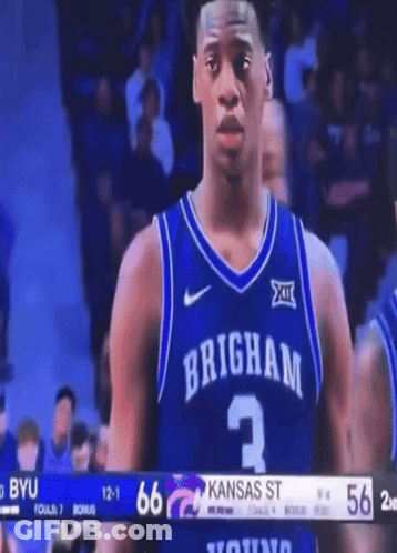 A Brigham Basketball Player Stands In Front Of A Scoreboard GIF