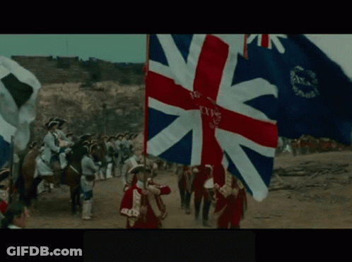 A British Flag Is Being Held By A Man In A Red Coat GIF