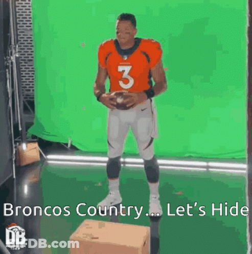 A Broncos Football Player Is Standing In Front Of A Green Screen And Holding A Football . GIF