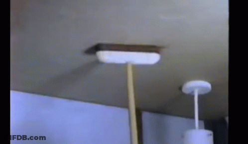 A Broom Is Hanging From A Ceiling In A Room . GIF