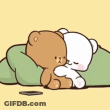 A Brown And White Teddy Bear Are Laying On A Green Pillow . GIF