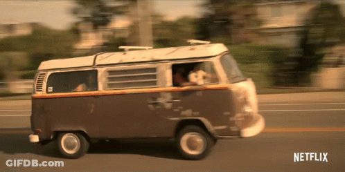 A Brown And White Van Is Driving Down A Street With Netflix Written On The Bottom Of The Screen GIF