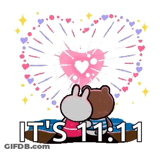 A Brown Bear And A Bunny Are Sitting On A Beach Watching Fireworks . GIF