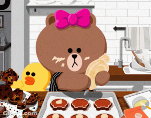 A Brown Bear With A Pink Bow On Her Head Is Baking Cookies In A Kitchen GIF