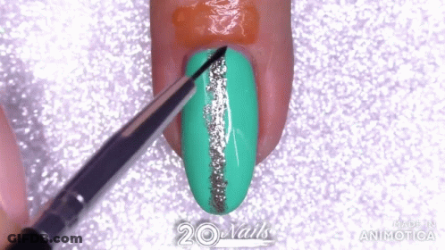 A Brush Is Being Used To Paint A Green Nail With A Silver Line GIF