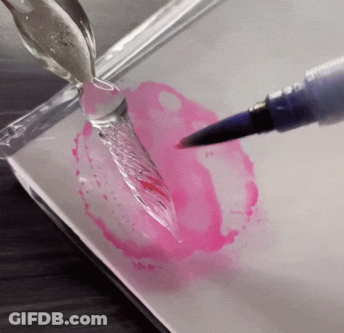 A Brush Is Being Used To Paint A Pink Circle On A White Surface GIF