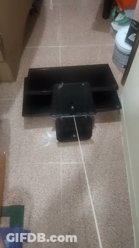 A Bucket Of Paint Sits On The Floor Next To A Shelf GIF