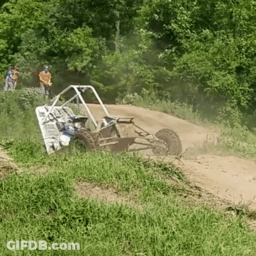 A Buggy Is Driving Down A Dirt Road With People Watching In The Background GIF