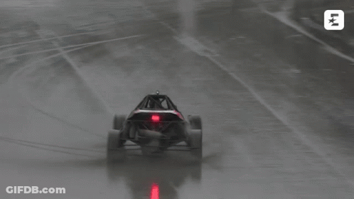 A Buggy Is Driving On A Wet Track With The Letters Lk On The Bottom Left GIF