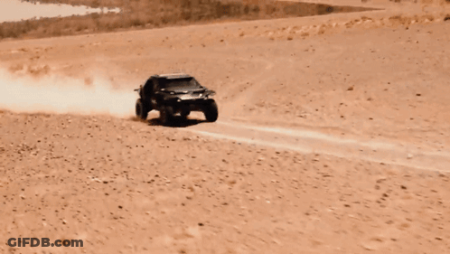 A Buggy Is Flying Through The Air In A Desert Landscape GIF