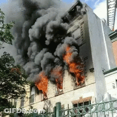 A Building That Is On Fire With Smoke Coming Out Of It GIF