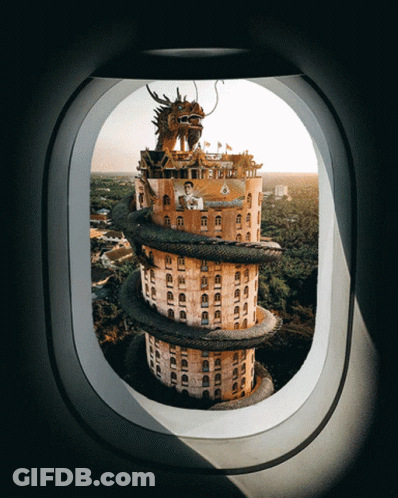A Building With A Dragon On Top Of It Is Seen Through An Airplane Window GIF