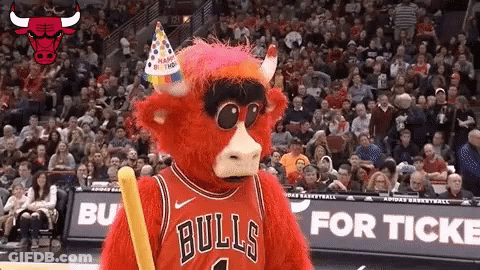 A Bulls Mascot Wearing A Birthday Hat And Holding A Stick GIF
