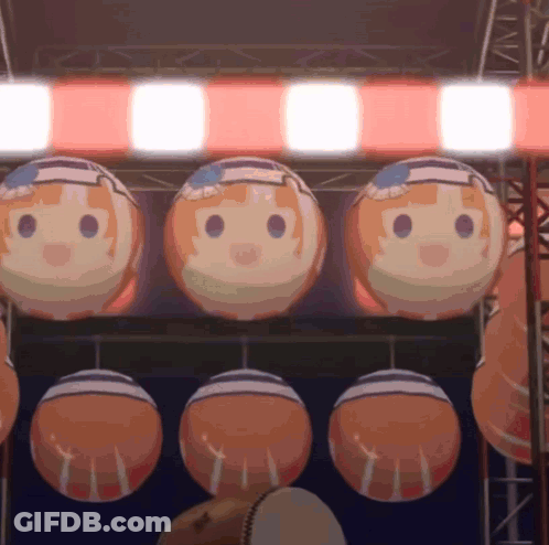 A Bunch Of Balls With Faces On Them Hanging From A Ceiling GIF