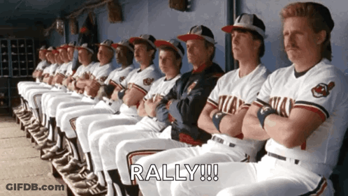 A Bunch Of Baseball Players Are Sitting In A Dugout And The Word Rally Is On The Bottom Right GIF