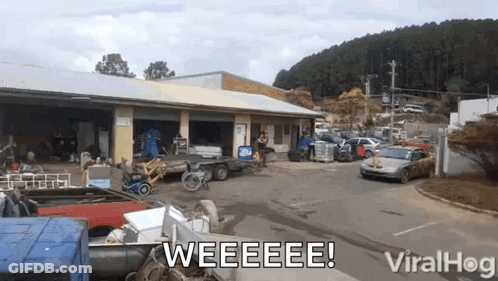 A Bunch Of Cars Are Parked In Front Of A Building With The Words Weeeee On It GIF