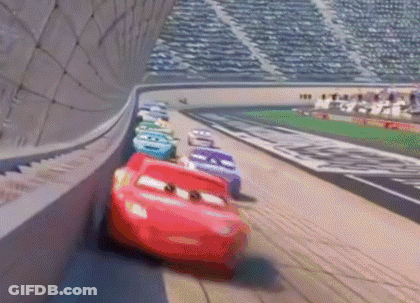 A Bunch Of Cars Are Racing On A Race Track . GIF