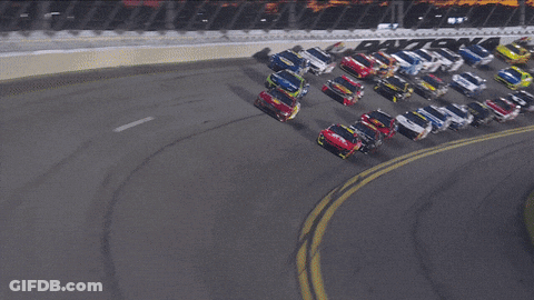 A Bunch Of Cars Are Racing On A Track With A Sign That Says ' Toyota ' GIF