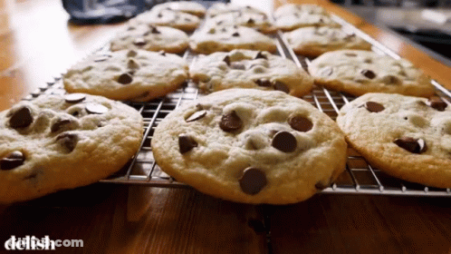 A Bunch Of Chocolate Chip Cookies On A Cooling Rack With The Word Delish Below Them GIF