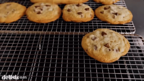 A Bunch Of Chocolate Chip Cookies On A Cooling Rack With The Word Delish On The Bottom GIF