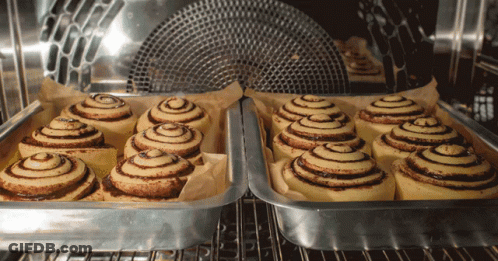 A Bunch Of Cinnamon Rolls Are In A Pan In An Oven GIF