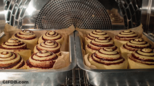 A Bunch Of Cinnamon Rolls Are In A Pan In An Oven GIF