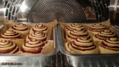 A Bunch Of Cinnamon Rolls Are In A Pan In An Oven GIF
