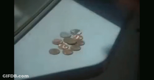A Bunch Of Coins On A Table With One That Says ' A ' On It GIF