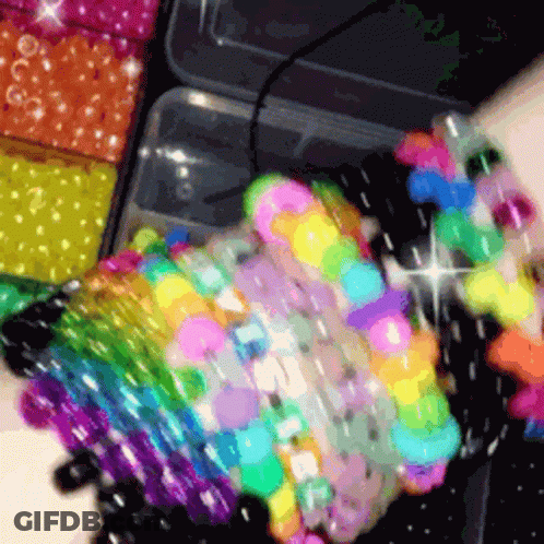 A Bunch Of Colorful Beads Are Stacked On Top Of Each Other On A Table GIF