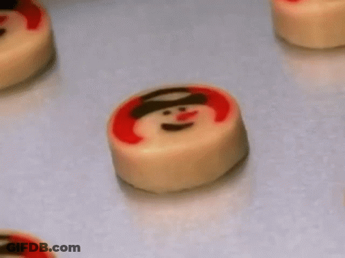 A Bunch Of Cookies With Snowmen On Them On A Table . GIF