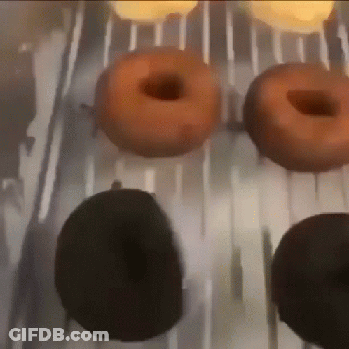 A Bunch Of Donuts Are Sitting On A Tray GIF