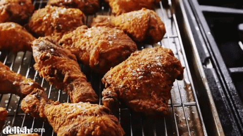 A Bunch Of Fried Chicken On A Rack With The Word Delish On The Bottom Right GIF