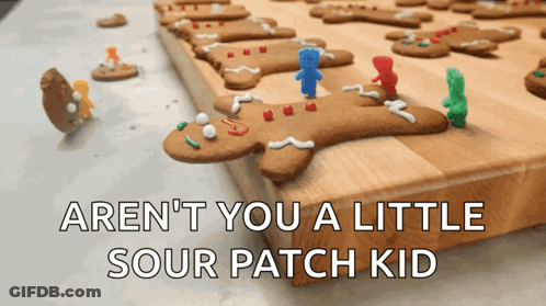 A Bunch Of Gingerbread Men On A Cutting Board With The Words Aren T You A Little Sour Patch Kid GIF