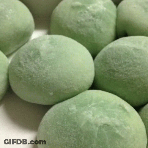 A Bunch Of Green Ice Cream Balls Are On A White Surface . GIF