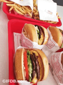 A Bunch Of Hamburgers Are On A Red Tray With French Fries GIF