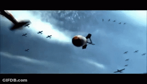 A Bunch Of Planes Are Flying In The Sky With A Bomb Flying In The Middle GIF