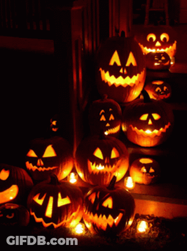 A Bunch Of Pumpkins With Faces Carved Into Them Are Lit Up At Night GIF