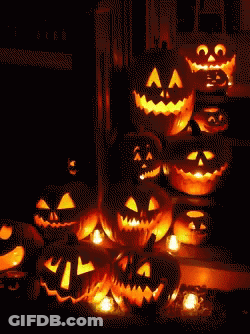 A Bunch Of Pumpkins With Faces Carved Into Them Are Lit Up In The Dark GIF