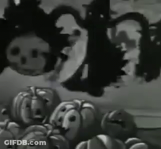 A Bunch Of Pumpkins With Faces On Them Are Sitting On A Table . GIF
