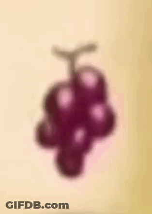 A Bunch Of Purple Grapes Are Floating In The Air . GIF