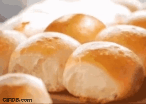A Bunch Of Rolls Are Sitting On A Table . GIF